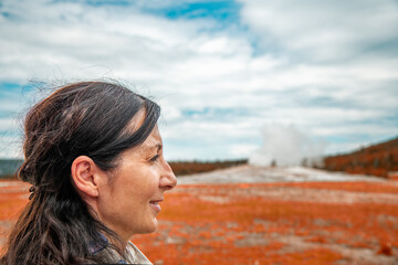 Woman witnessing the eruption of Old Faithful Geyer, Yellowstone National Park