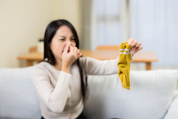 Woman hold with smells stinky sock