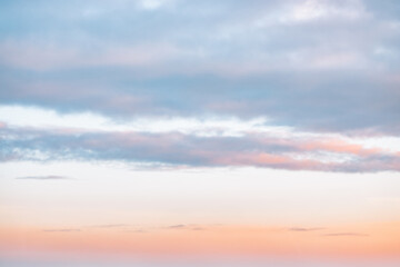 A beautiful sky tinted by the sun leaving vibrant shades of gold, pink, blue and multicolored. Clouds in the twilight evening and morning sky. Cloudy sky background in the evening and during the day.