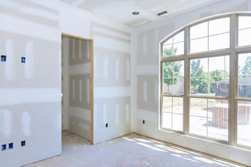Gypsum plaster walls are in process of being finished for painting in new home - obrazy, fototapety, plakaty