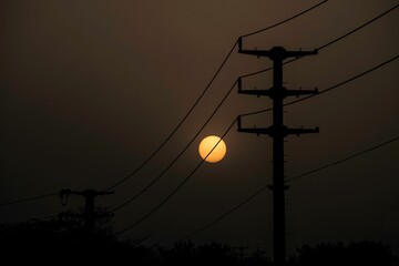 electricity power line pylon and sun setting down