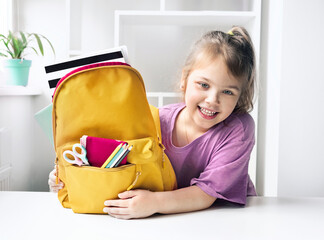 Caucasian child girl portrait with backpack.Back to school concept,school supplies.