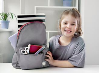 Caucasian child girl portrait with backpack.Back to school concept,school supplies.