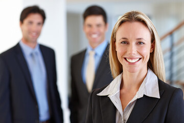 Businesswoman, portrait and colleagues with smile at office for work, joy or young and confident. Female person, coworkers and happy at job with real estate or property, realtor or professionals