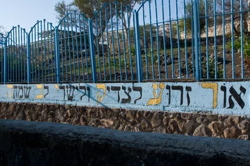 Fotobehang Hebrew verse from Psalm 97 on a wall beside the tomb of Rabbi Akiva, which translates to: Light is sown for the righteous, and, for the upright of heart, joy. © Yehoshua Halevi