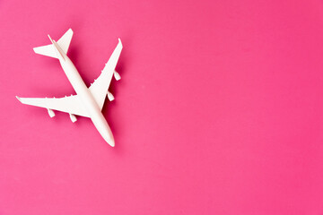 White colored toy commercial airplane isolated on pink background composition with copy space....
