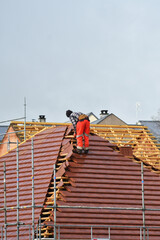 ouvrier couvreur sur un toit d'une construciion - 776162010