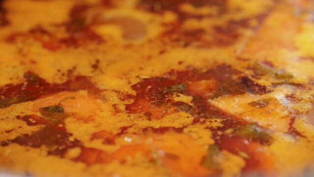 Hungarian goulash soup cooking close-up in pot, chef cook traditional polish or zech soup in restaurant. 