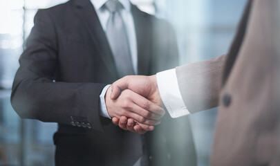 colleagues shaking hands in the office lobby