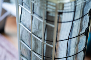 A window with a mesh screen on it. The mesh screen is made of metal and is on a white surface