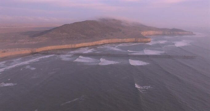Shot of dock at sunset, with the seafront behind. Aerial shot of the Puerto Eten beach sea at sunset.