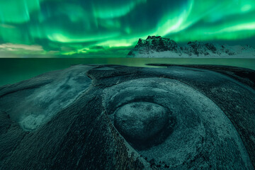Northern Lights in Uttakleiv beach over the rock formation known as The Dragon's Eye (low angle view), Uttakleiv beach, Lofoten and Vesteral Islands, Nordland, Northern Norway, Norway
