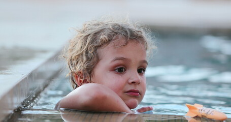 Portrait of handsome baby boy inside swimming pool water