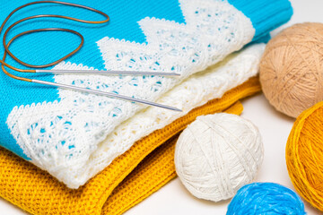 wool knitting needles lie on a knitted sweater.