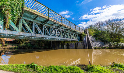 A panorama view along an old railway bridge over the Grand Union Canal in Aylestone Meadows, Leicester, UK in Springtime
