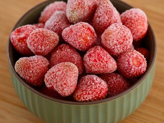 Frozen organic strawberries in a bowl.