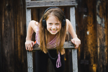 Portrait of a funny little girl wearing headphones. - 776202268