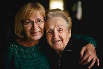 Portrait of an older woman with her adult daughter. - 776202484