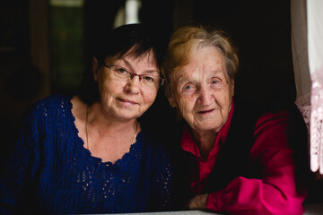 Portrait of an elderly woman with her adult daughter.