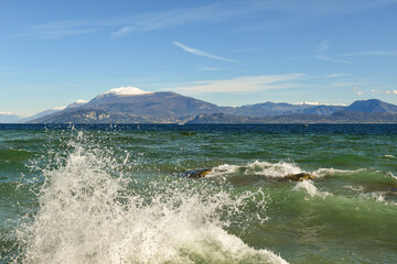 High waves on Lake Garda with Monte Baldo (2,218 m), a mountain range in the Italian Alps, in the background, Sirmione, Brescia, Lombardy, Italy