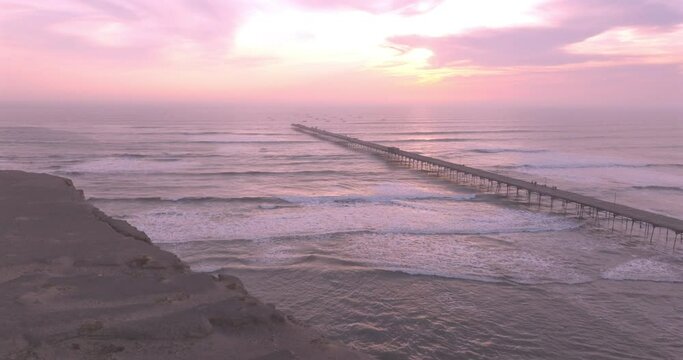 Shot of dock at sunset, with the seafront behind. Aerial shot of the Puerto Eten beach sea at sunset.