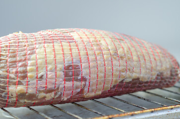A piece of meat is being prepared for cooking on a grill - 776205883