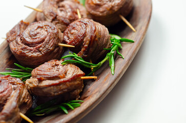 A plate of pieces of meat in the shape of roses with green herbs on top - 776206848