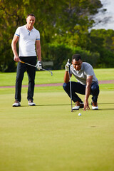 Men, play and aim golf ball at hole for sport, fitness or health in outdoor competition on summer...