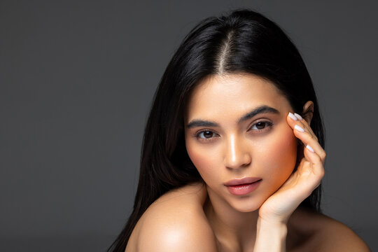 Gorgeous woman face portrait. Beauty Model Girl with bright eyebrows, perfect make-up, red lips, touching her face.