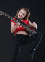 girl playing bass guitar on black backround