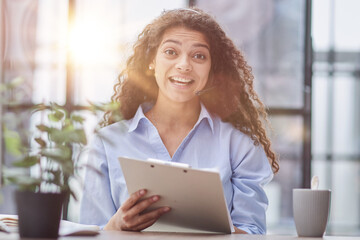 Brunette business woman using headset to communicate and advise people in customer service office.