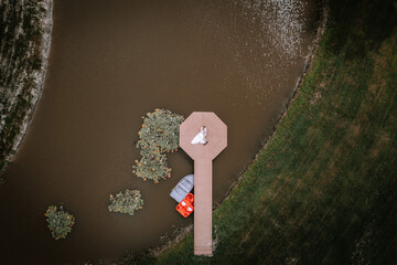 Valmiera, Latvia - Augist 13, 2023 - An aerial view of a bride and groom standing on an octagonal...