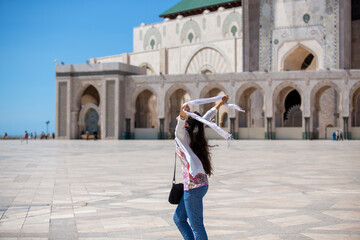 Fototapeta premium Joyful Woman With Scarf at Mosque Courtyard