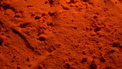 Small bright orange crystals of potassium dichromate, close up, abstract colorful background, rotates