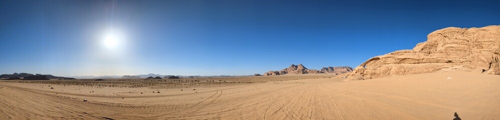 Fototapeta na wymiar Panoramic view of Wadi Rum desert in Jordan with clouds moving over flat sand landscape with mountains and rocks formations.Discover beauty of the earth. National park outdoors landscape.UNESCO