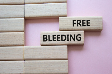 Free bleeding symbol. Concept words Free bleeding on wooden blocks. Beautiful pink background....