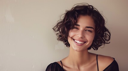 Enchanting brunette with captivating curls, framed against a neutral backdrop. Her warm smile radiates joy, while her short, wavy hairstyle exudes modern elegance. - obrazy, fototapety, plakaty