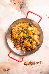 Pan-fried potatoes with mushrooms and onions in a frying pan