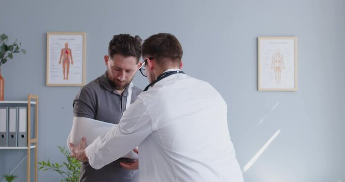 Doctor or nurse is examining a patient with a broken arm during a hospital visit. Medical staff provides care and treatment for the trauma, ensuring the patient receives quality care and support.