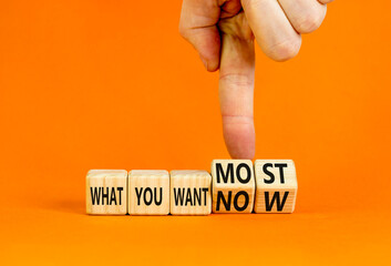 What you want now or most symbol. Concept word What you want now or most on cubes. Beautiful orange background. Psychologist hand. Psychological what you want now or most concept. Copy space.