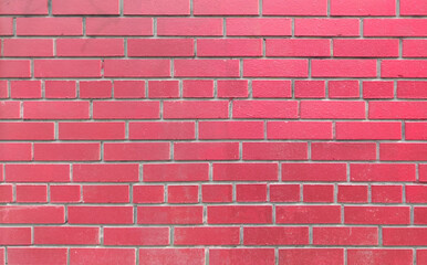 The wall is made of bright red brick, a natural material, stone masonry. Texture for indoor or outdoor background, loft interior.