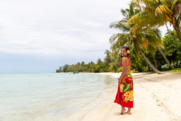 French Polynesia Tahiti luxury travel beach vacation woman walking in sarong on island, French Polynesia. Image is completely unretouched, model has no makeup. Authentic real people. Raw Image