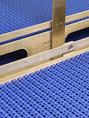 A close-up of a blue polyurethane belt in modular industrial conveyor system. Stainless steel...