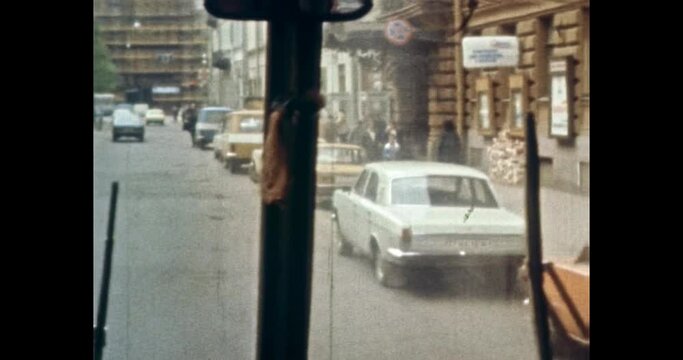 POV from bus front window street view, people walking on sidewalk. 1980s Petersburg, Russia. Public transport moving on city road. Vintage, old archives. Archival color film. Retro, historic archive