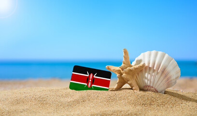 Fototapeta na wymiar Tropical beach with seashells and Kenya flag. The concept of a paradise vacation on the beaches of Kenya.
