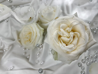 White and cream roses and pearls on a silver gray background.