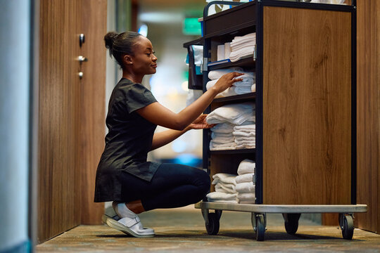 Young black hotel housekeeper at work.