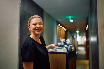 Young happy hotel housekeeper looking at camera.