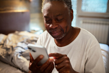 Senior man using smartphone at home