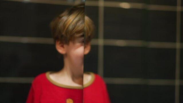 Smallb oy mirror reflection on bathroom mirror, playful kid looking at his own duplicate